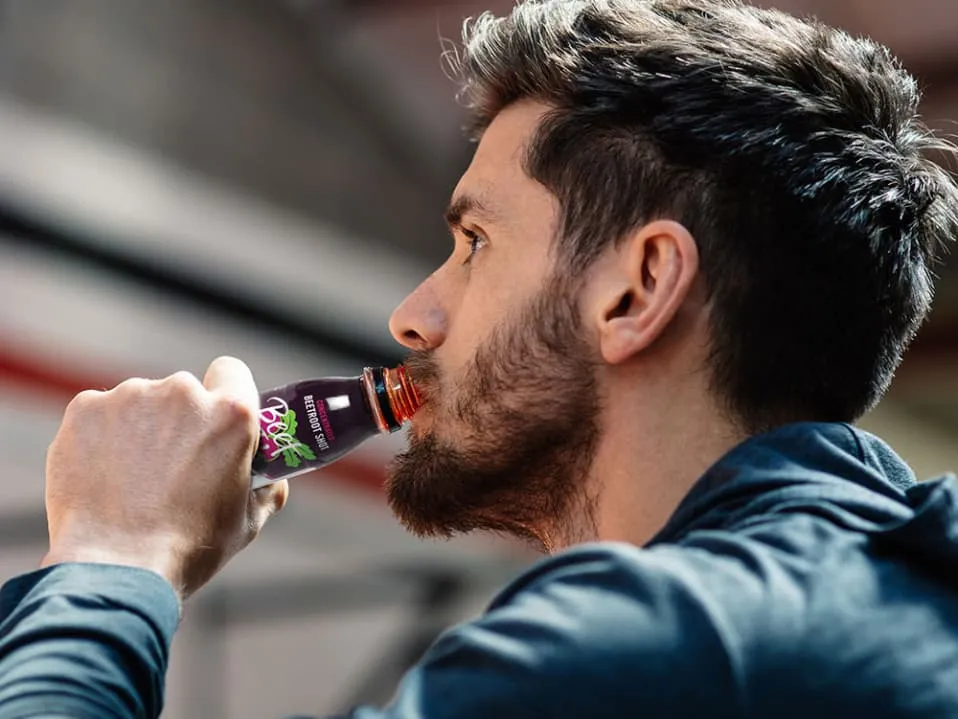 Sportowiec pije sok z buraka