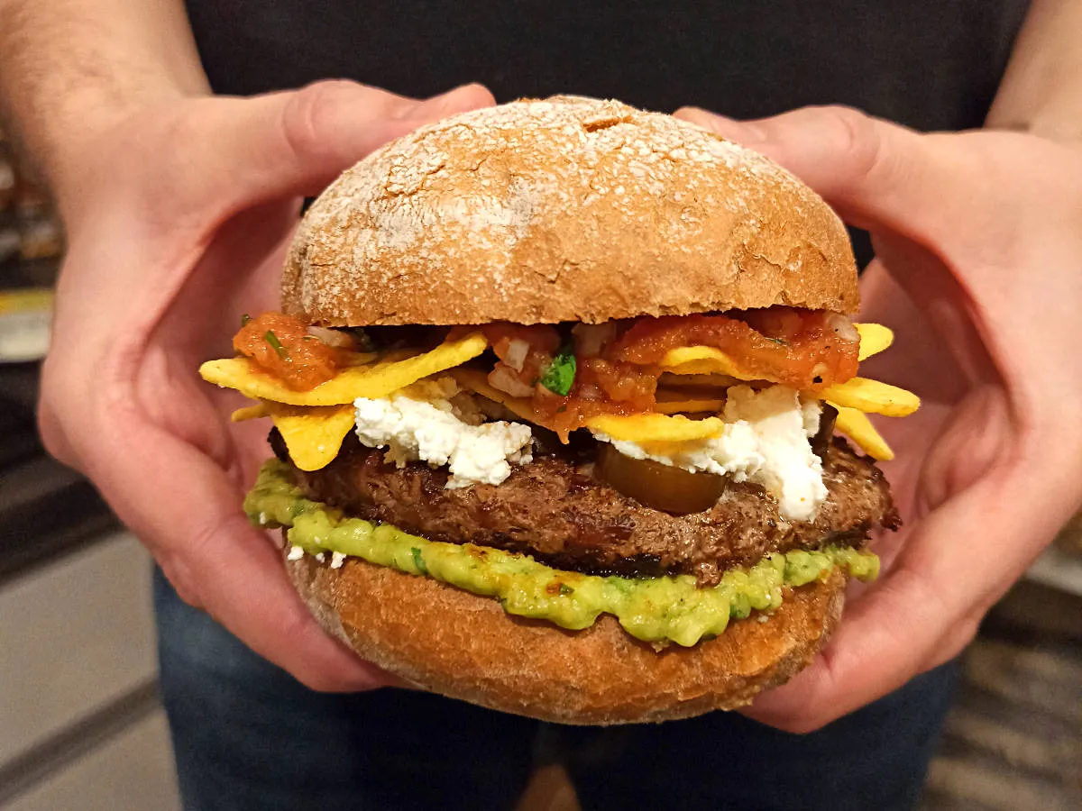 Pyszny burger z serem feta, nachos i salsą. Idealny pomysł, co zrobić z guacamole &ndash; nał&oacute;ż je obficie na sp&oacute;d bułki!