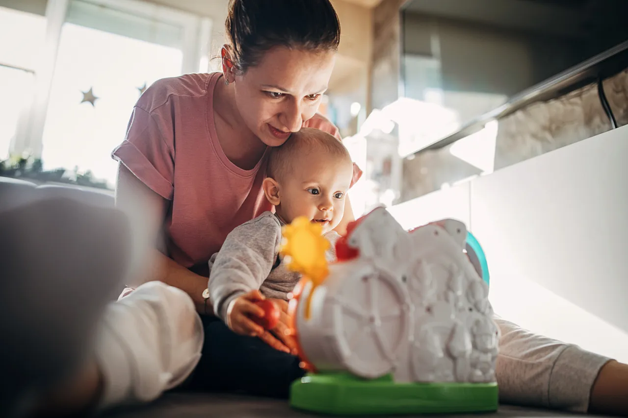 rodzic bawi się z niemowlęciem