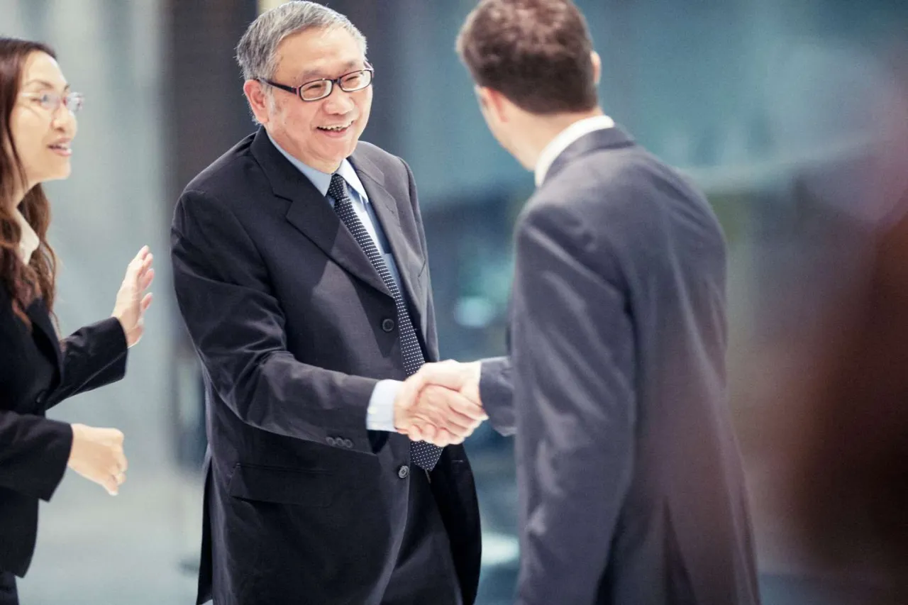 people from different cultures in a business meeting handshake