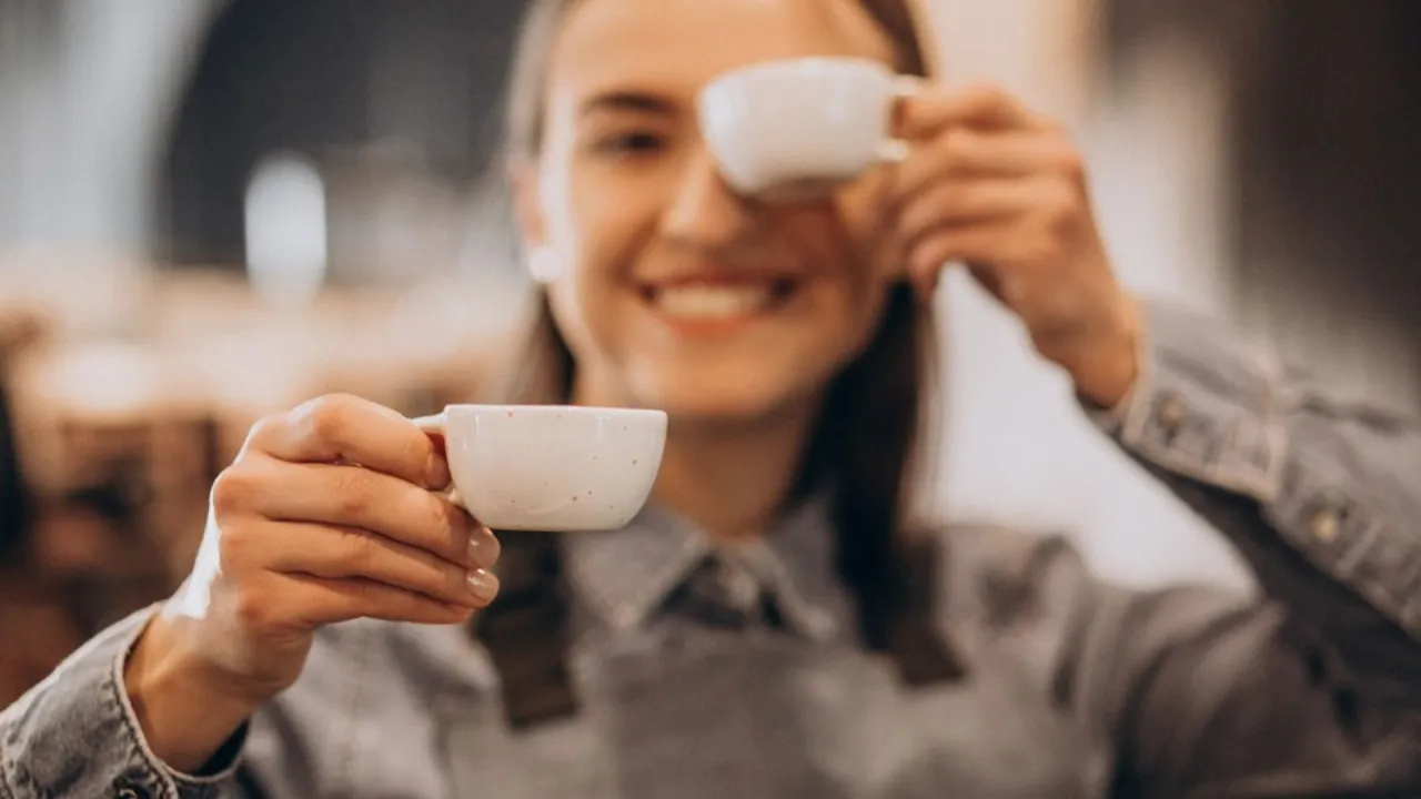 kobieta pije kawę z mlekiem z uśmiechem