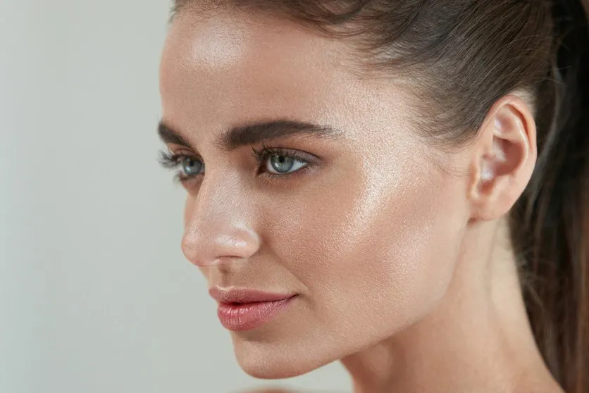 podkład rozświetlający z drobinkami złota na skórze efekt