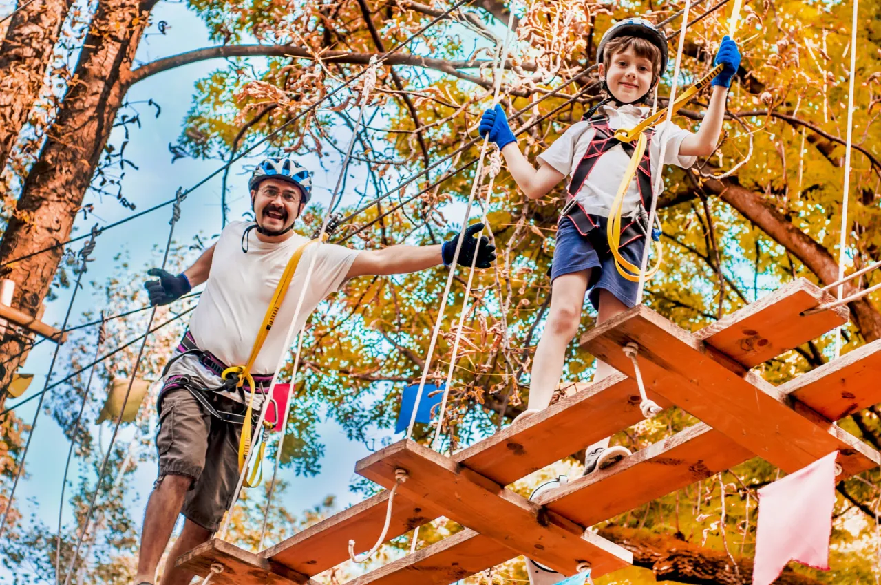 Rodzina w parku linowym, dzieci na trasie linowej