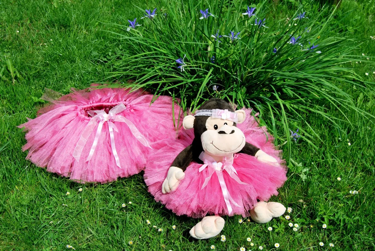 Dwie różowe spódniczki na gumce, jedna na pluszowym małpce, idealne do nauki jak uszyć spódniczkę na gumce dla dziewczynki.