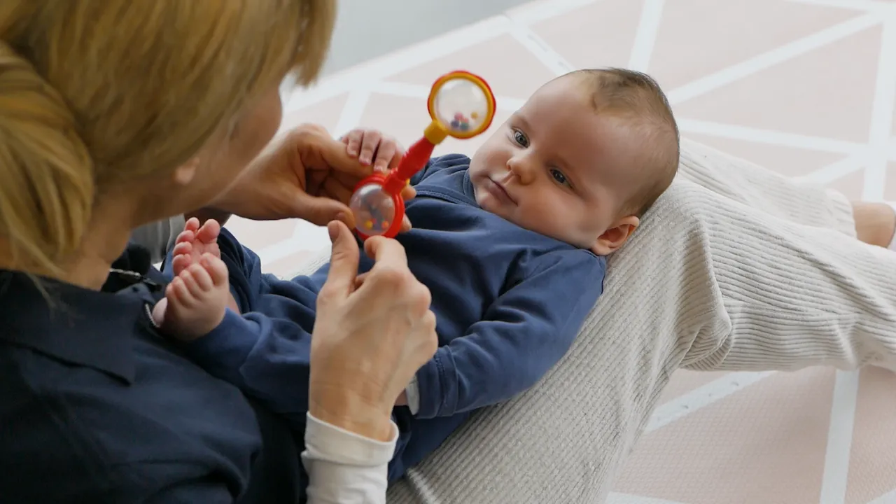 szczęśliwe niemowlę bawiące się grzechotką