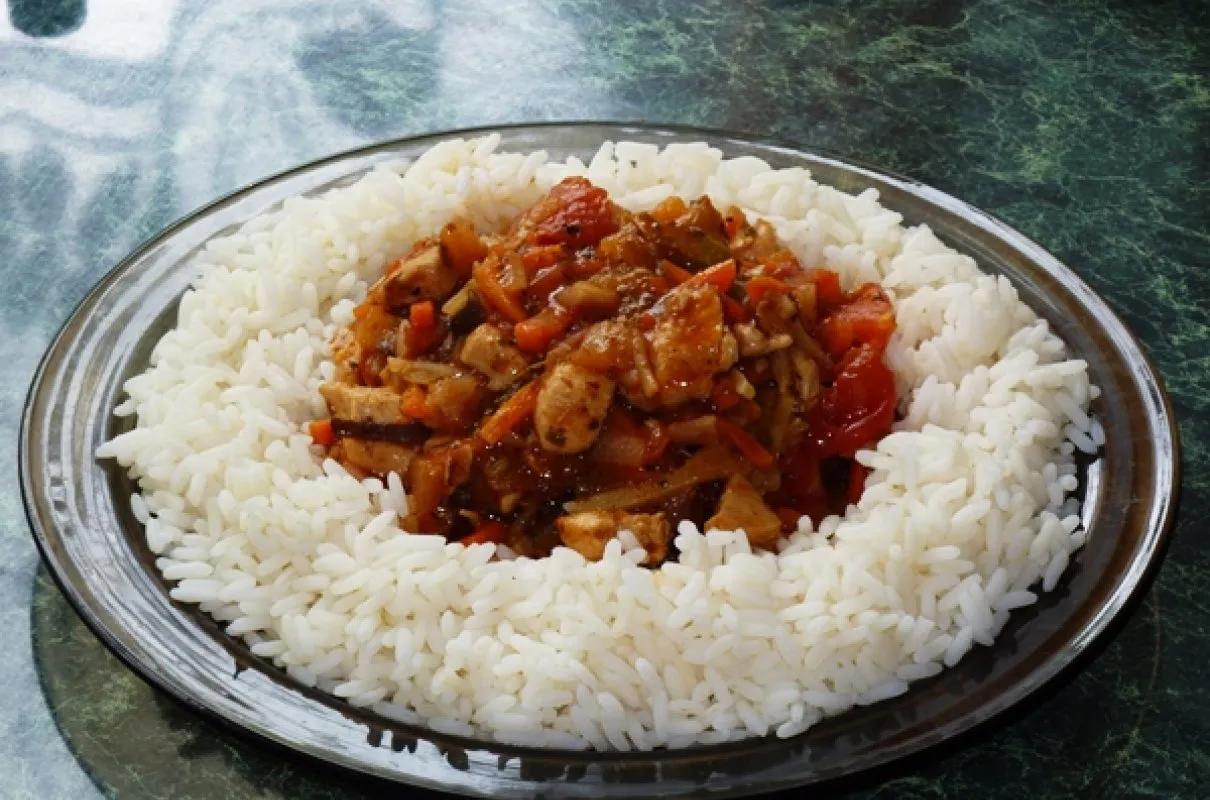 Pyszne warzywa po chińsku z kurczakiem i papryką, podane na talerzu z ryżem.