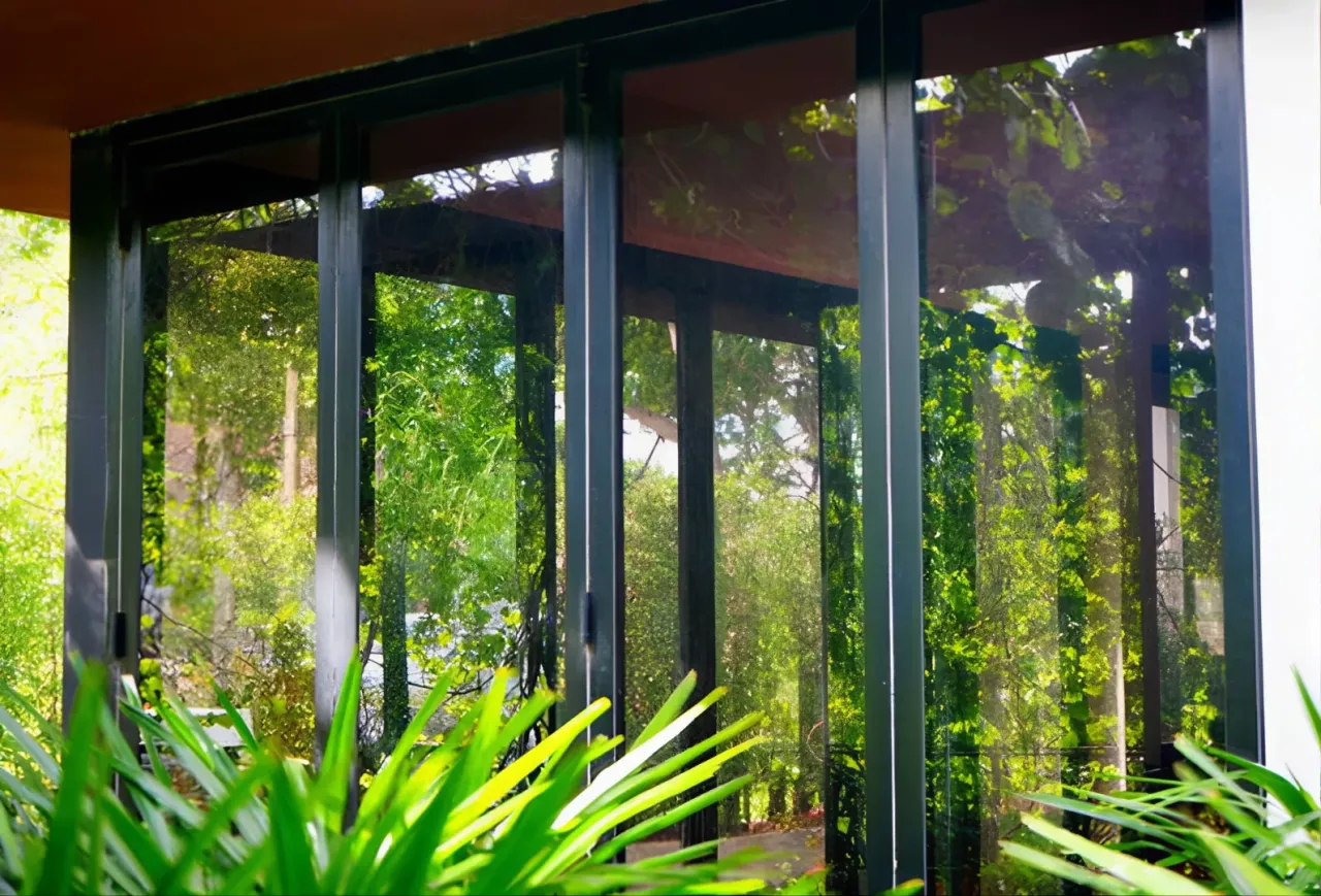 Okna antracyt wady: odbijają zieleń, tworząc iluzję głębi. Wady? Czasem trudno odróżnić wnętrze od ogrodu.