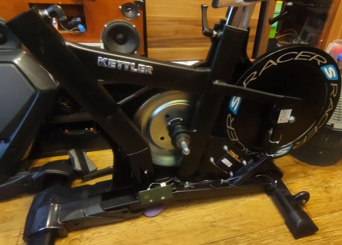 Naprawa oporu w rowerze magnetycznym Kettler Racer. Widoczny mechanizm i koło zamachowe.