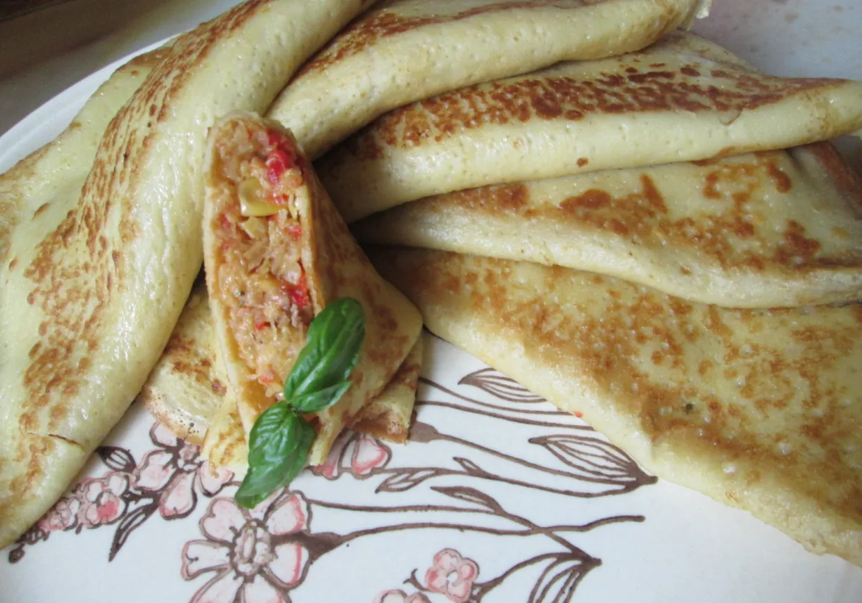 Naleśniki przepis na pyszne danie. Zobacz, jak łatwo przygotować te złociste naleśniki z farszem, ozdobione listkiem bazylii.