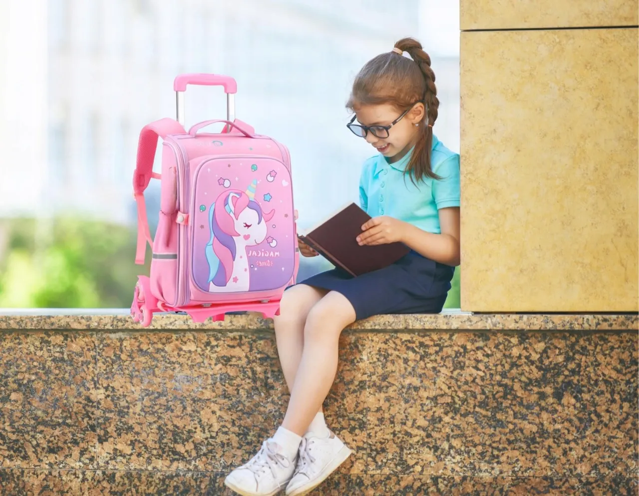 dziecko z plecakiem na kółkach w szkole