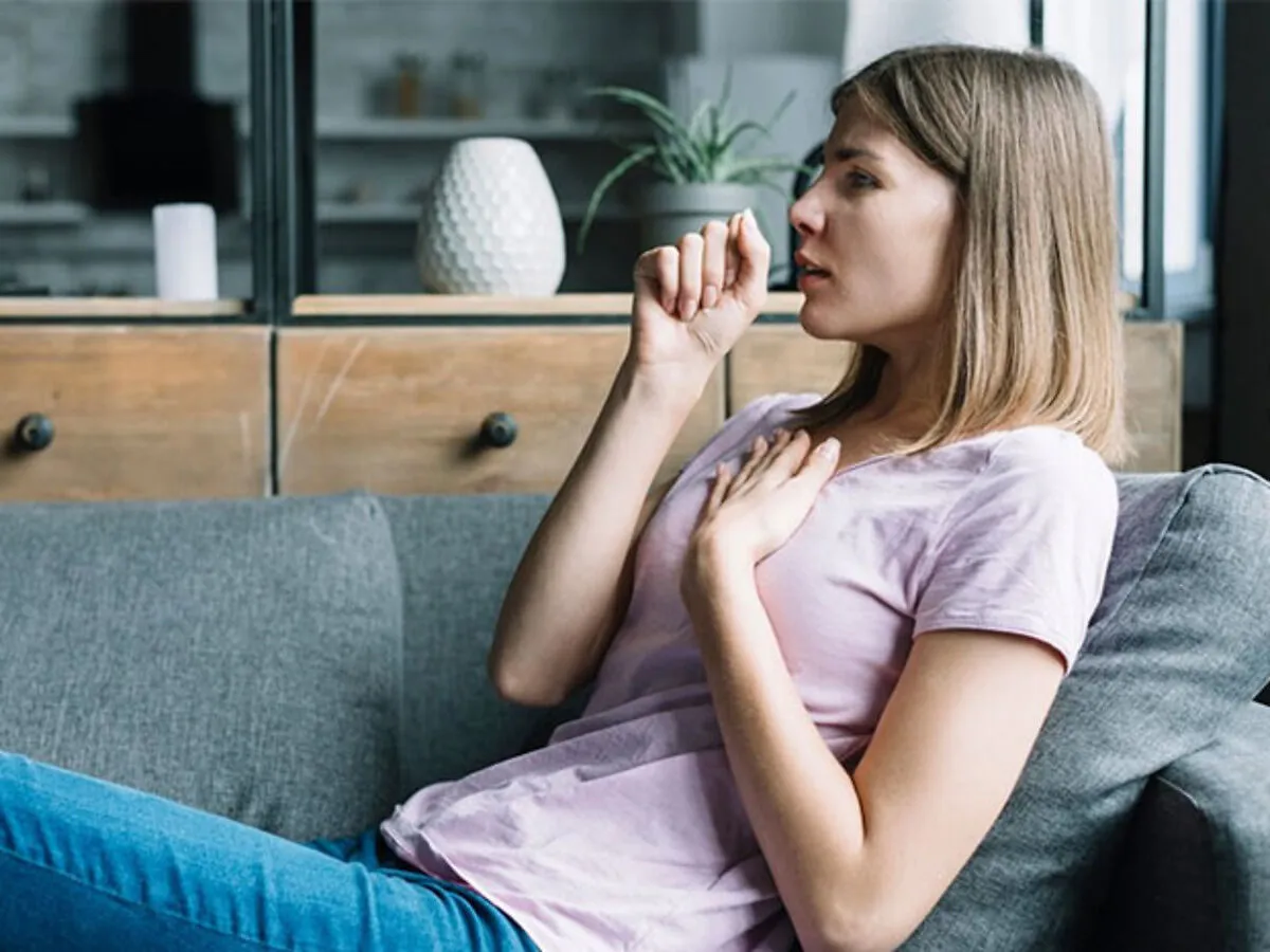 osoba z objawami lęku, trzymająca się za serce, z rozmazanym tłem