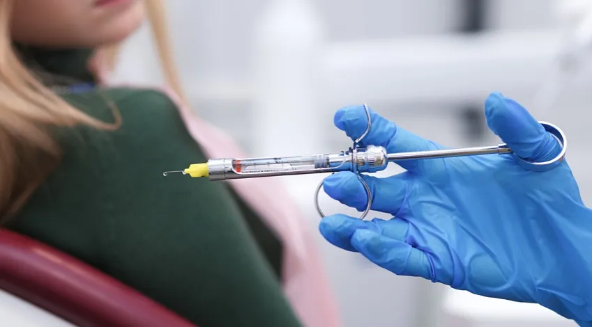 Dentysta podaje znieczulenie, strzykawka stomatologiczna, pacjent u dentysty