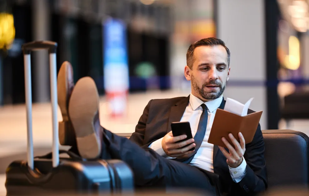 Pracownik w delegacji sprawdza telefon