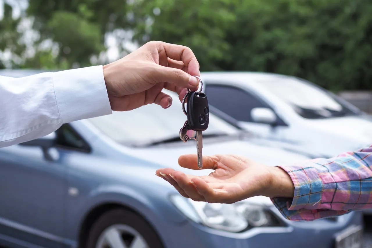 Przekazanie kluczyków do samochodu po wykupie z leasingu na cele prywatne. Nowy właściciel odbiera auto.