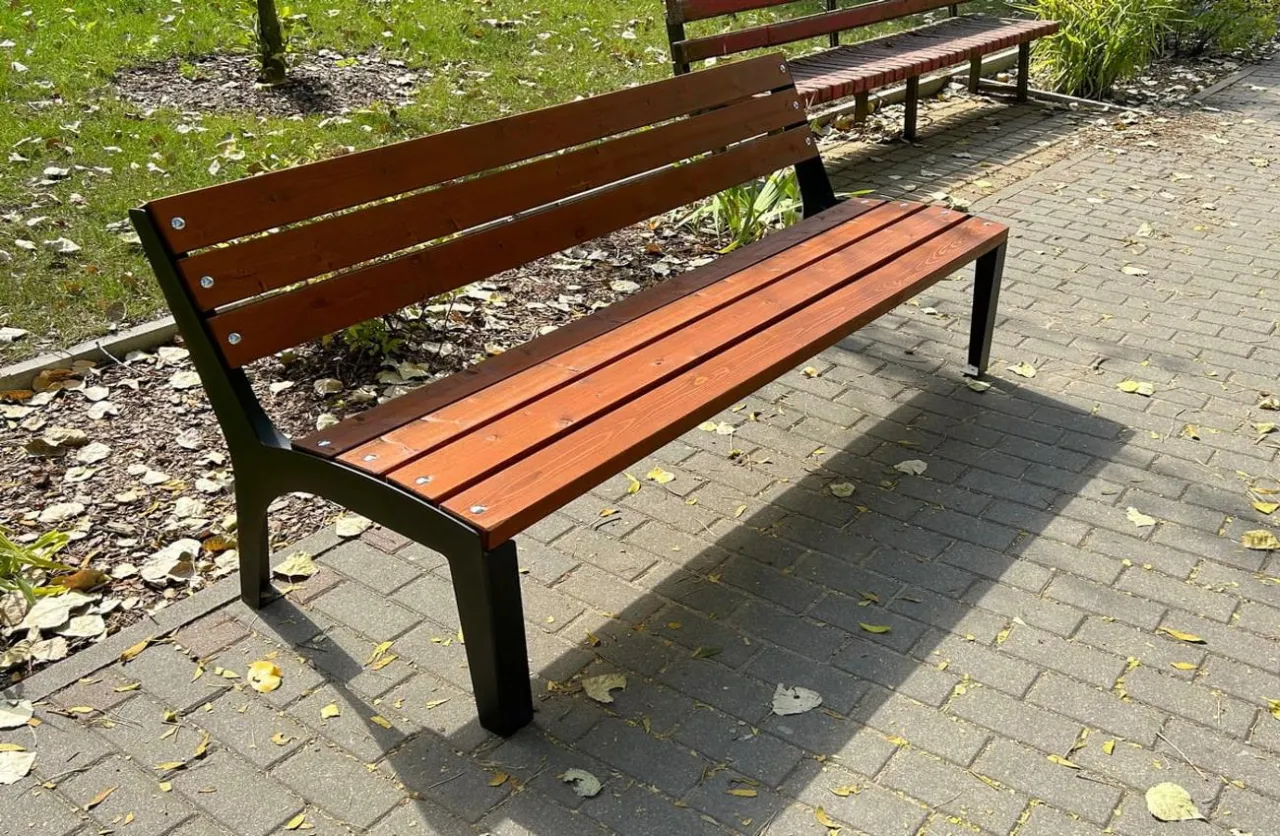 Prosta ławka parkowa z drewnianym siedziskiem i oparciem na czarnych metalowych nogach. Idealna do ogrodu, instrukcja jak wykonać prostą ławkę.