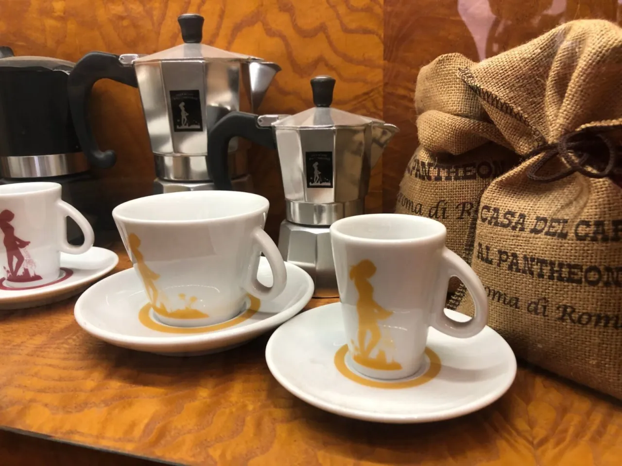 Kawa i pamiątki z Rzymu: filiżanki z motywem kobiety i kawy, kawiarki, worki z napisem 