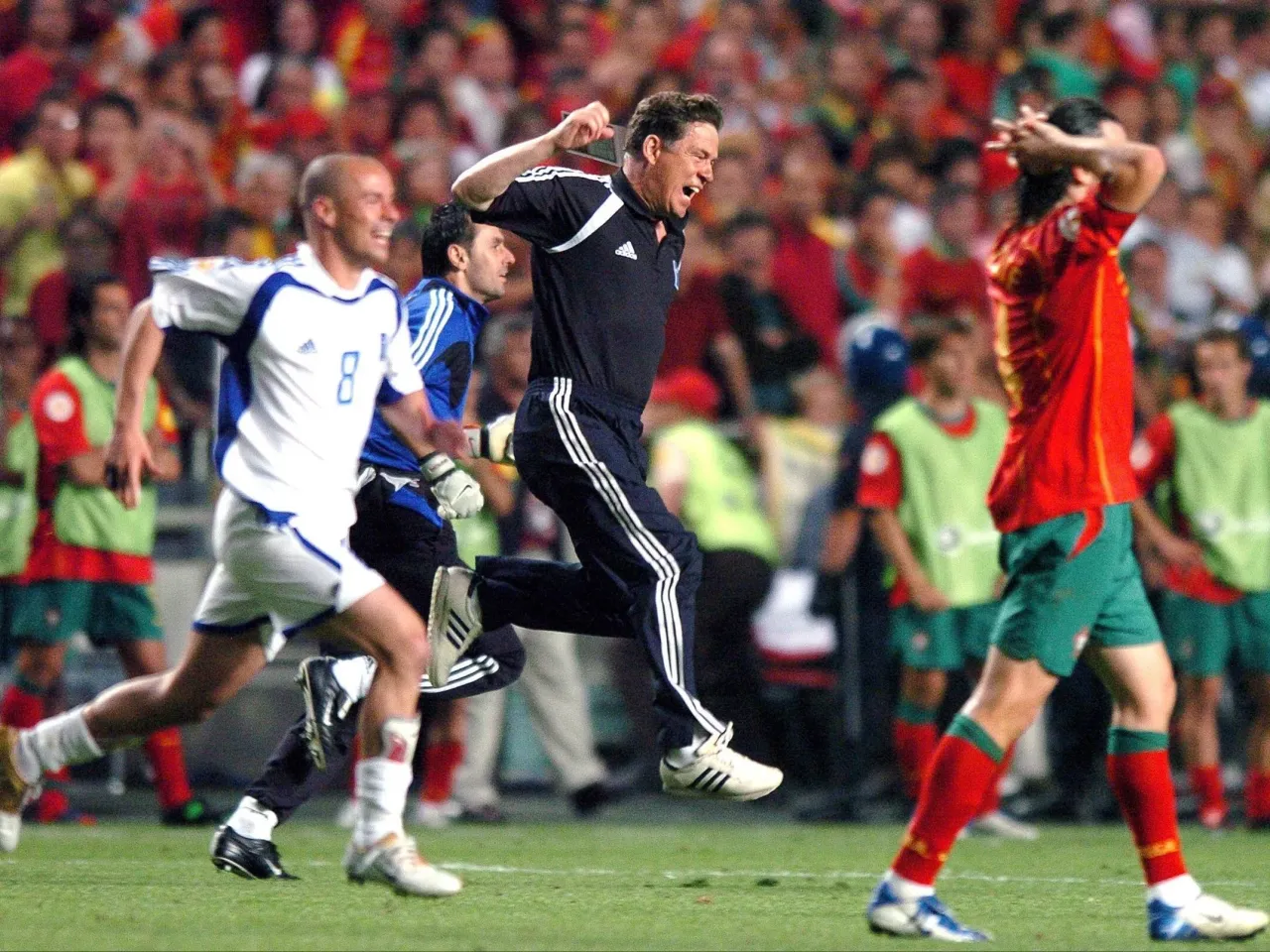 Trener świętuje, gdy jego drużyna, kt&oacute;ra zdobyła mistrzostwo Europy w piłce nożnej, biegnie po boisku.