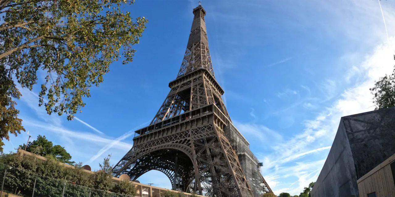 Wieża Eiffla w Paryżu, z jej charakterystyczną kratownicą, wznosi się na tle błękitnego nieba. Zastanawiasz się, ile schodów ma Wieża Eiffla?