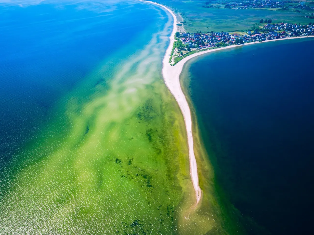 Wąska, piaszczysta mierzeja na P&oacute;łwyspie Helskim, otoczona turkusową i granatową wodą. Widok z lotu ptaka na najpiękniejsze miejsce na p&oacute;łwyspie helskim.