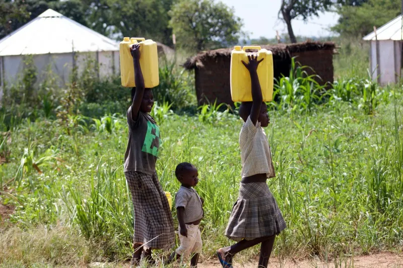 Kobiety i dzieci niosące wodę w Afryce
