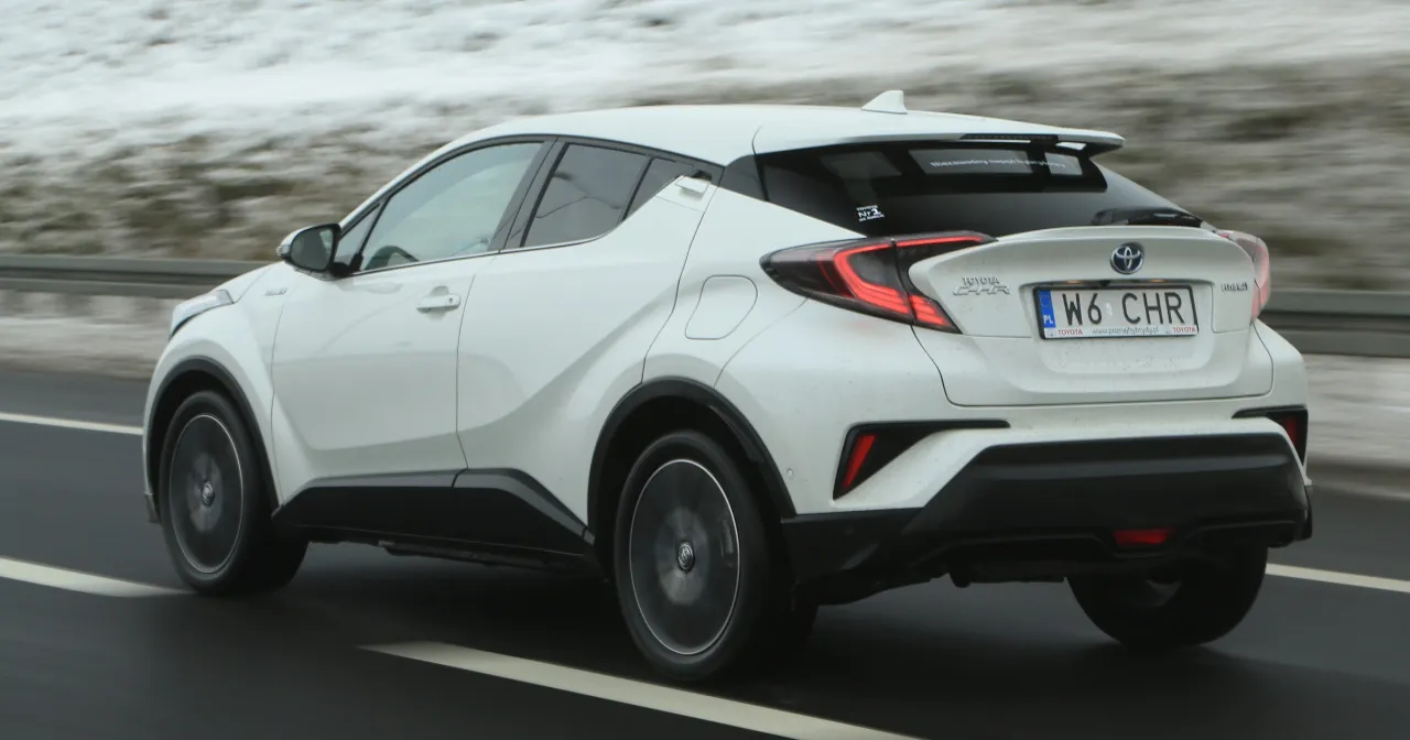 Biała Toyota C-HR Hybrid w ruchu drogowym. Kierowcy zastanawiają się, ile pali Toyota C-HR Hybrid, a ten model pokazuje, że jest to ekonomiczny wybór.