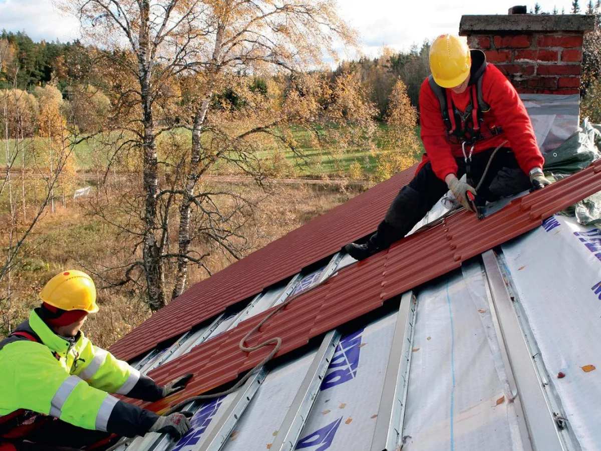 dekarz przy pracy na dachu nowoczesny dom