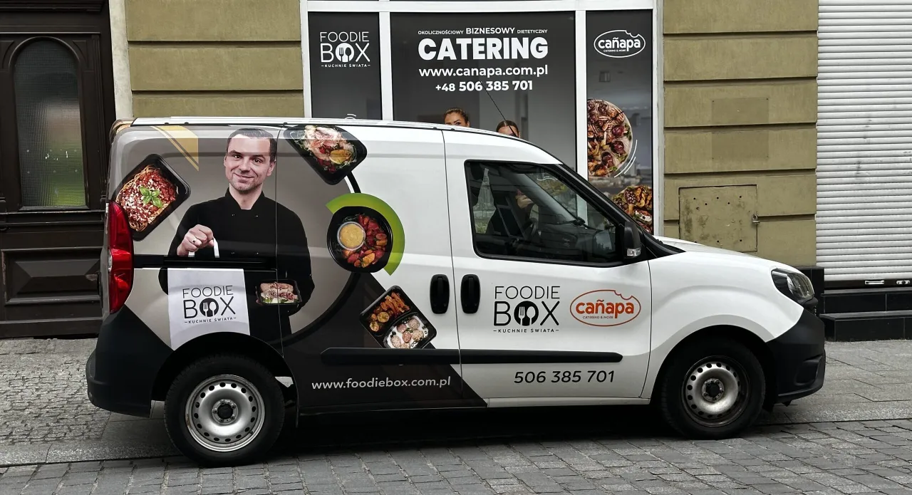 Foodie Box: diet catering z dostawą. Na samochodzie widać kucharza i apetyczne dania.