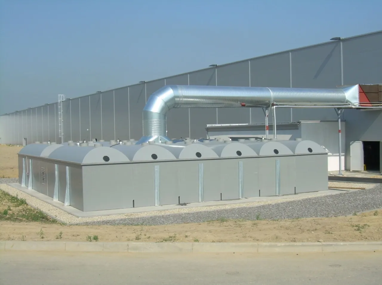 Nowoczesna biogazownia z dużym, metalowym kanałem wentylacyjnym. Czy biogazownia śmierdzi? Zależy od technologii i konserwacji.