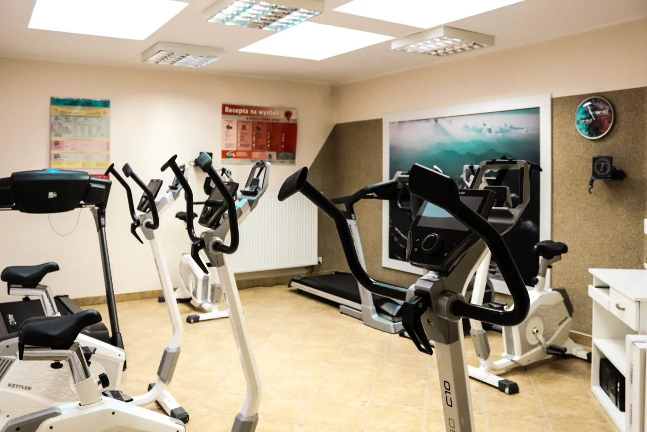 Siłownia z rowerkami stacjonarnymi i bieżnią, idealne miejsce, gdzie najlepsza rehabilitacja kardiologiczna staje się rzeczywistością.
