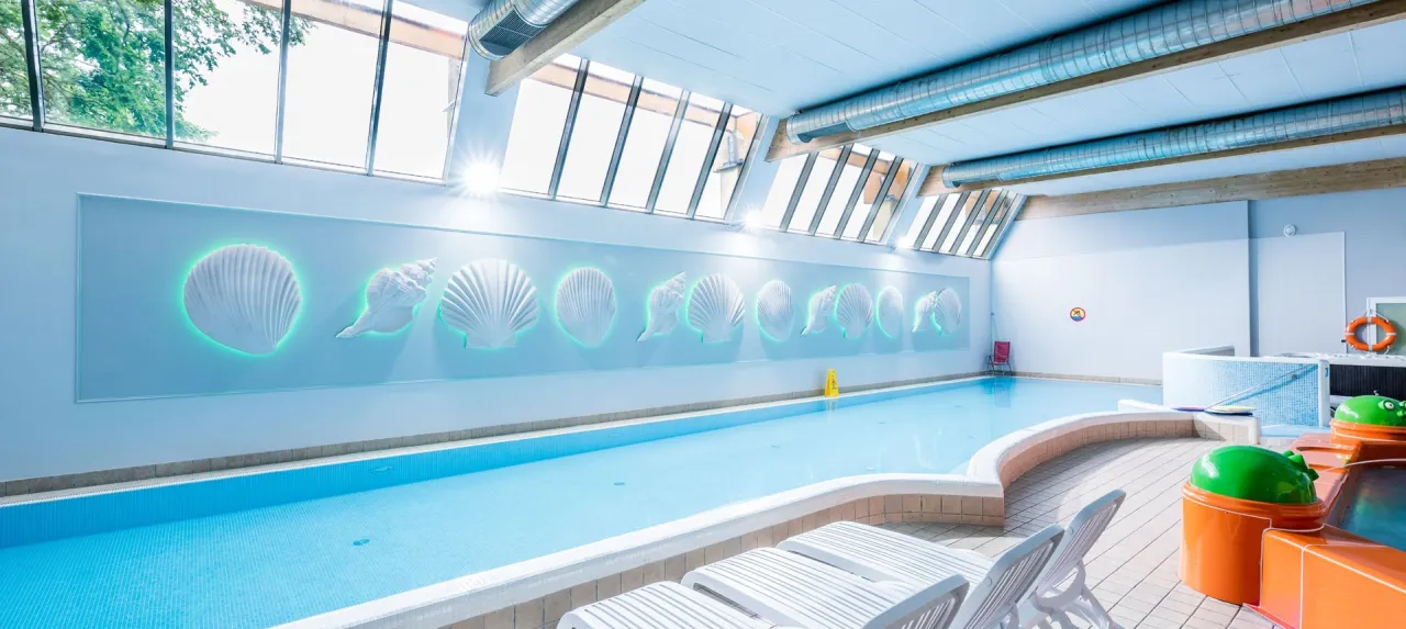 Basen z dekoracjami muszli, idealny na tanie wczasy nad morzem dla 2 osób z wyżywieniem. Relaks i zabawa gwarantowane!