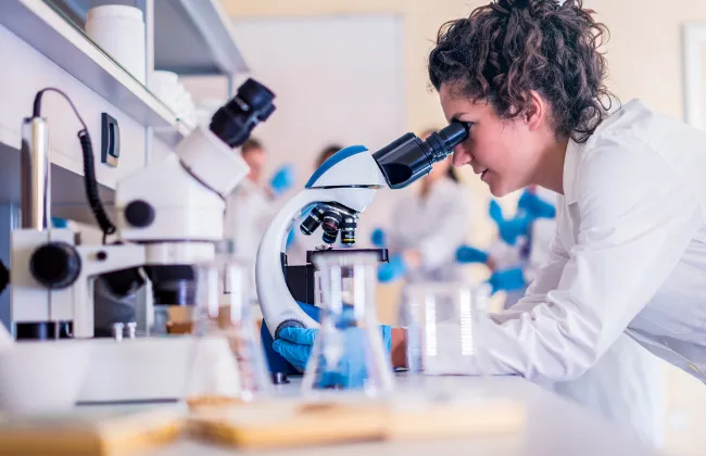 Biolog sądowy w laboratorium, analiza DNA, mikroskop