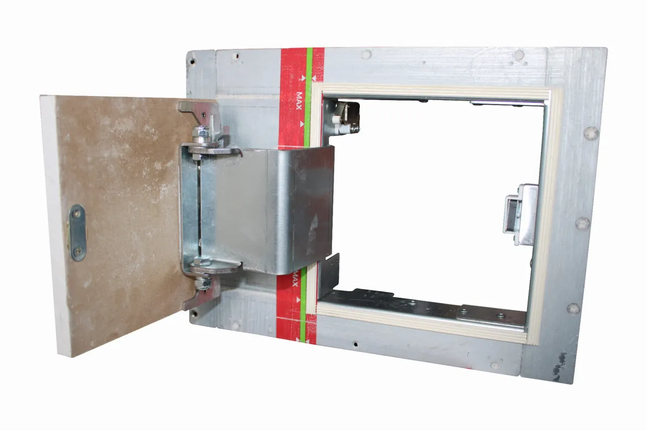 Instrukcja jak zamontować drzwiczki rewizyjne plastikowe. Metalowa rama z otwartymi drzwiczkami, widoczne zawiasy i mocowania.