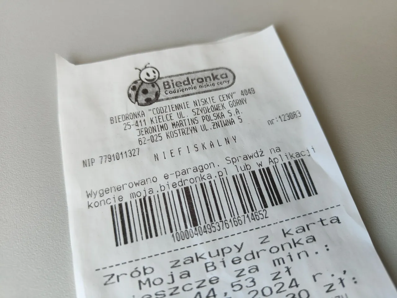 Jak wygląda faktura z Biedronki: paragon z logo biedronki, danymi sklepu, kodem kreskowym i informacją o e-paragonie.