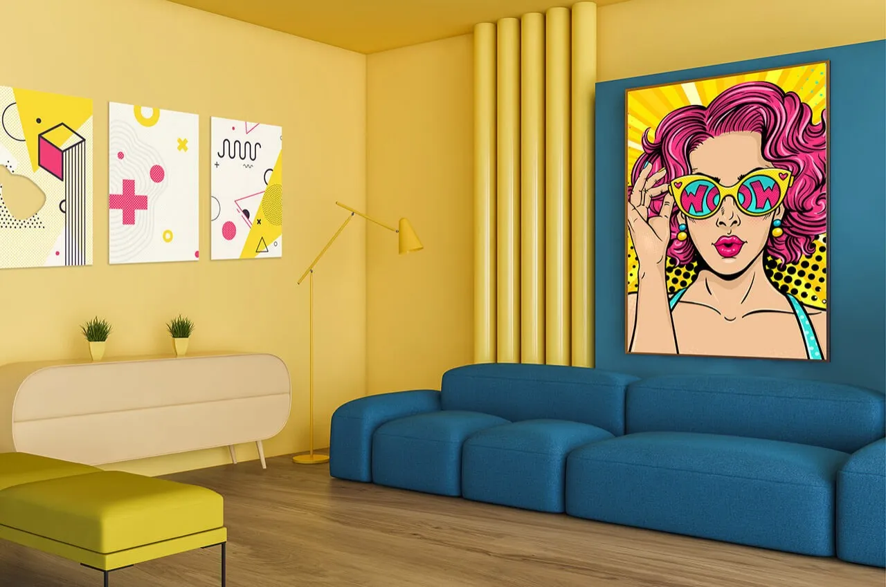 Żółty pokój z niebieską kanapą i żółtym pufem. Na ścianach wiszą kolorowe plakaty pop art, w tym jeden z kobietą w okularach z napisem 