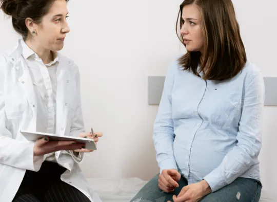 lekarz ginekolog rozmawia z ciężarną o zdrowiu