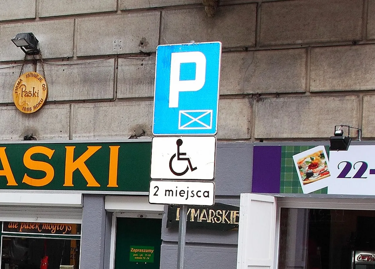 Znak drogowy informuje o dwóch miejscach parkingowych dla osób niepełnosprawnych.