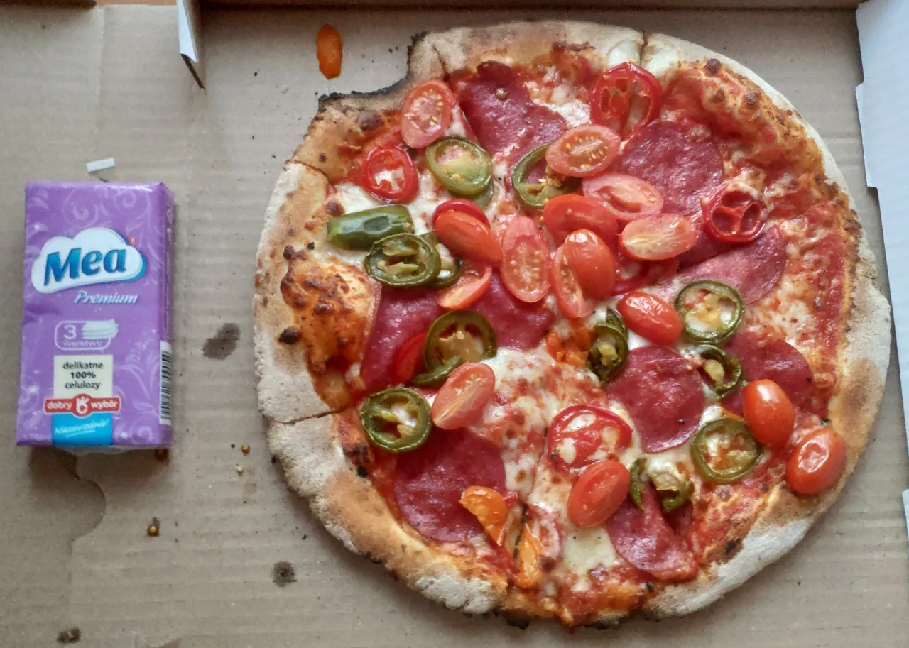 Pyszna pizza z salami, pomidorkami i papryczką jalapeno. Idealna na szybki posiłek, gdy zastanawiasz się, gdzie zjeść w Dębkach.