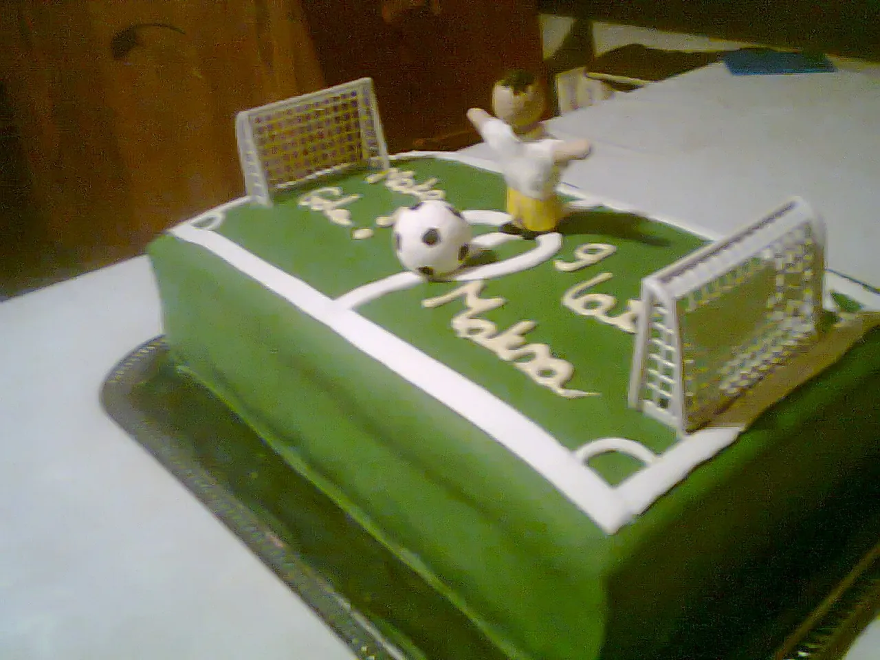 Jak zrobić tort boisko do piłki nożnej? Zielony tort z bramkami, piłką i figurką piłkarza.