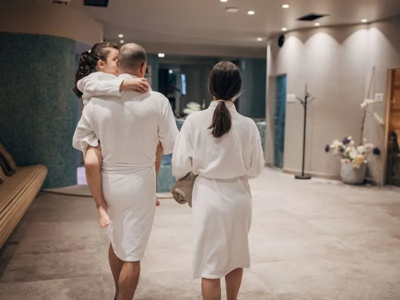 osoba w szlafroku idąca na basen hotelowy