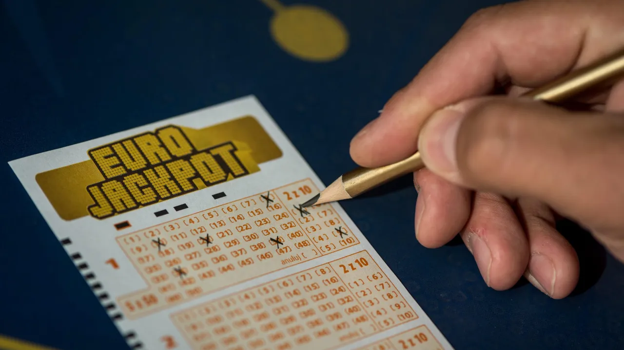 Dłoń zaznacza liczby na kuponie Eurojackpot. Jaka jest szansa wygrania w Eurojackpot? Mała, ale marzenia są wielkie!