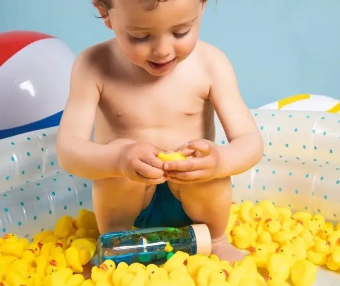 dziecko bawi się butelką sensoryczną