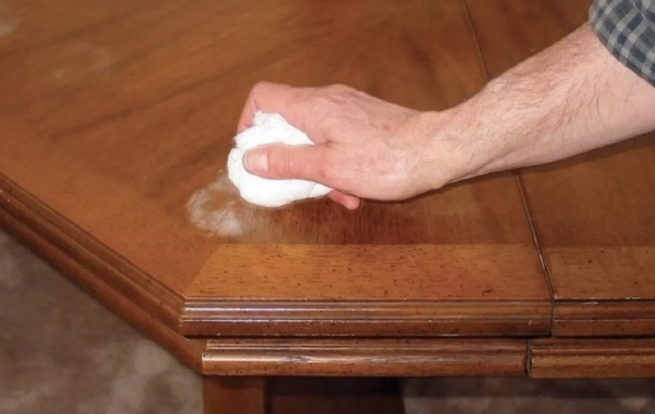 Kobieta susząca białą plamę na stole suszarką do włos&oacute;w