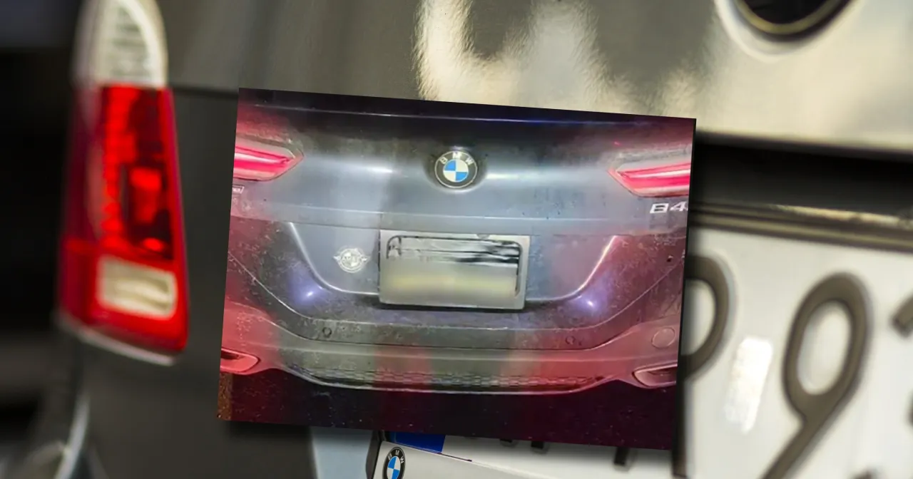 kierowca demontujący tablicę rejestracyjną