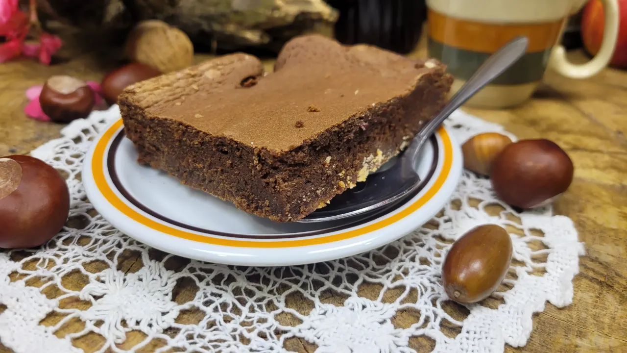 Pyszny kawałek brownie na talerzyku, otoczony kasztanami i żołędziami. Idealny na jesienny deser, zgodnie z tym brownie przepisem.