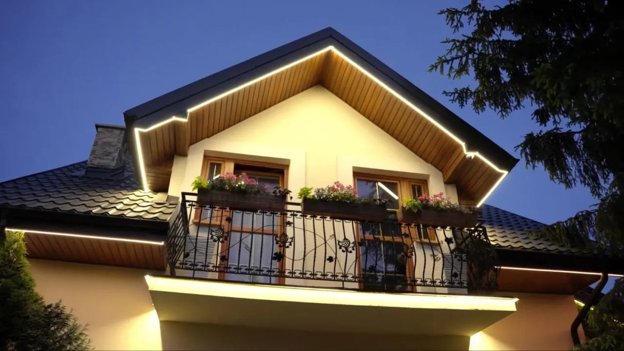 Eleganckie lampy w podbitce podkreślają architekturę domu, tworząc ciepłą atmosferę wieczorem.