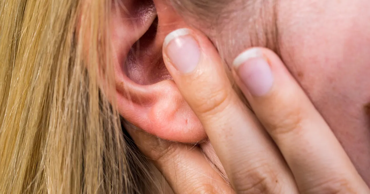 Osoba zestresowana z dłońmi przy uszach