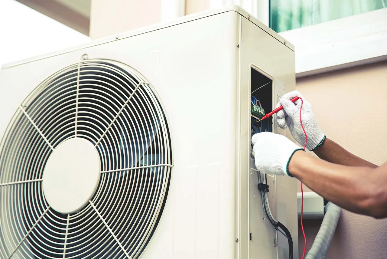 Technik sprawdza okablowanie pompy ciepła, szukając przyczyny, dlaczego pompa ciepła się nie włącza.