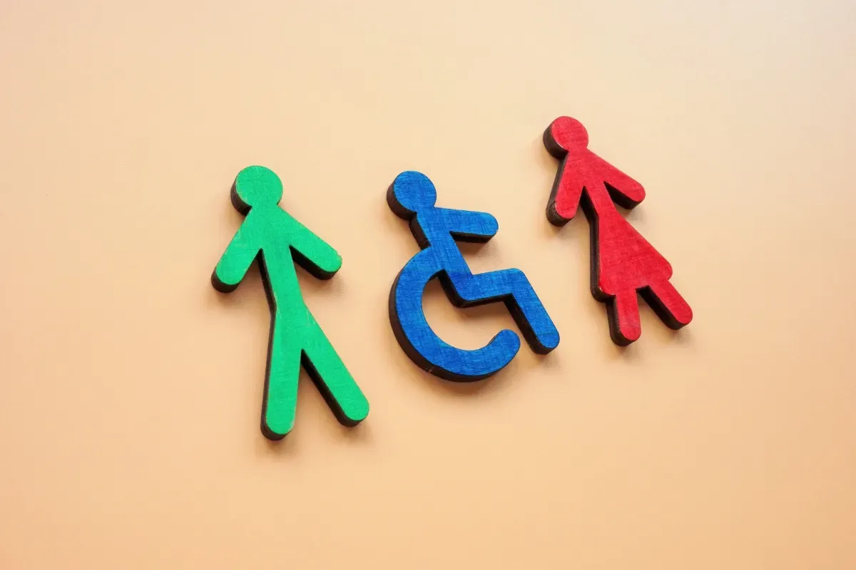 Trzy drewniane figurki: zielona, niebieska (niepełnosprawny) i czerwona. Symbolizują, komu przysługuje zasiłek za opiekę nad osobą starszą.