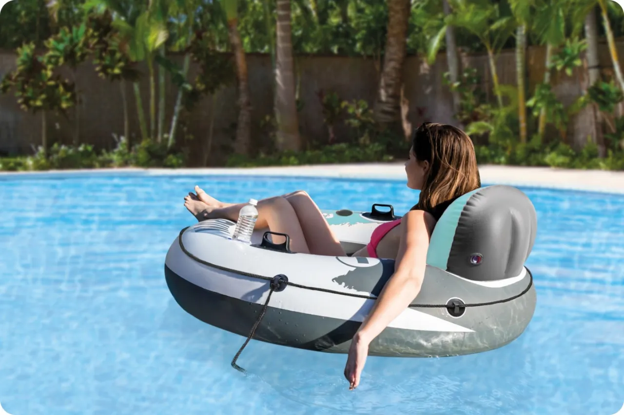 Kobieta relaksuje się na dmuchanym kółku do pływania dla dorosłych, unosząc się na błękitnej wodzie basenu.