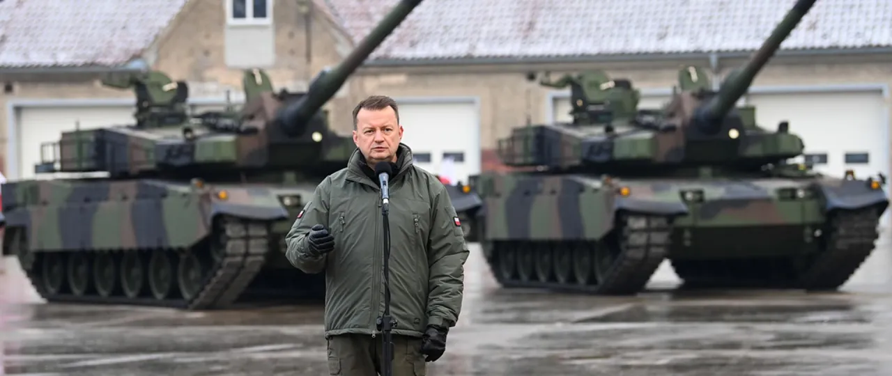 Mężczyzna w mundurze wojskowym przemawia przed czołgami. Dowiedz się, jak zostać kierowcą czołgu i dołączyć do wojska.